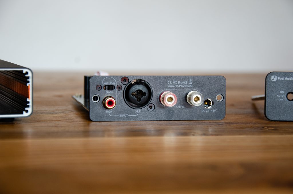 Fosi Audio V3 Mono zerlegt und Rückansicht mit RCA sowie XLR Eingang, Gain-Schalter, Lautsprecher Ausgang und Strom-Eingang