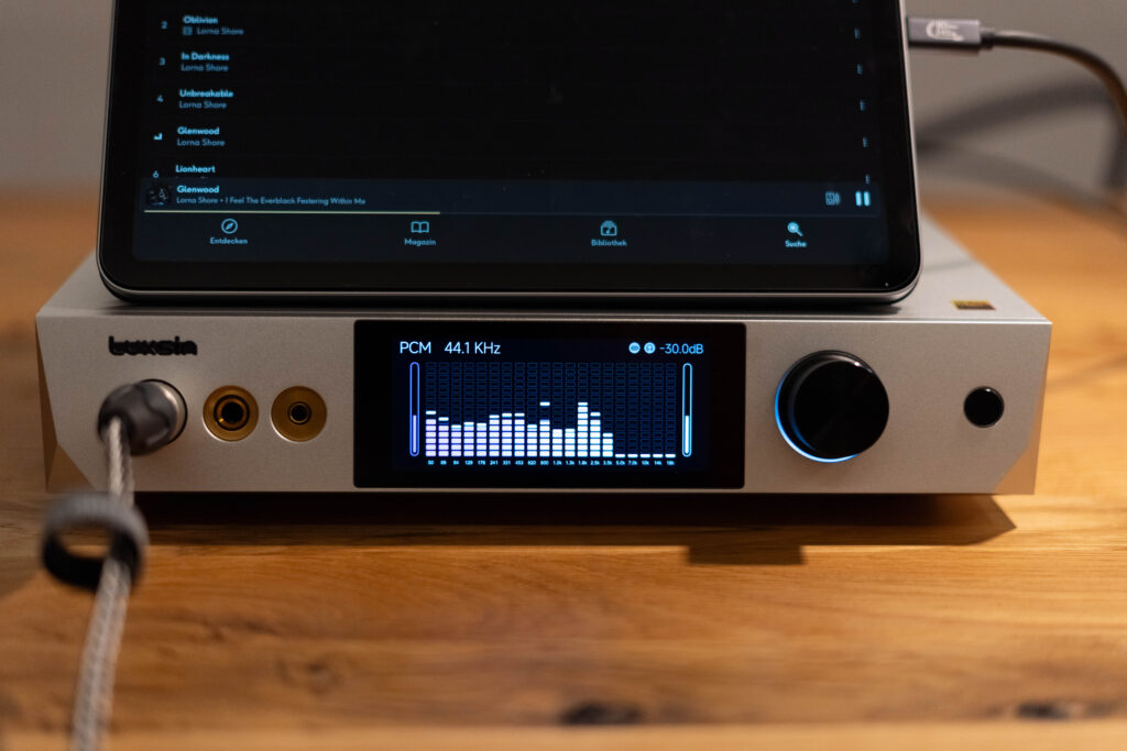 Luxsin X9 - mit Blick Frontal auf das Display mit VU-Meter und iPad mit Qobuz und spielt Glenwood von Lorna Shore