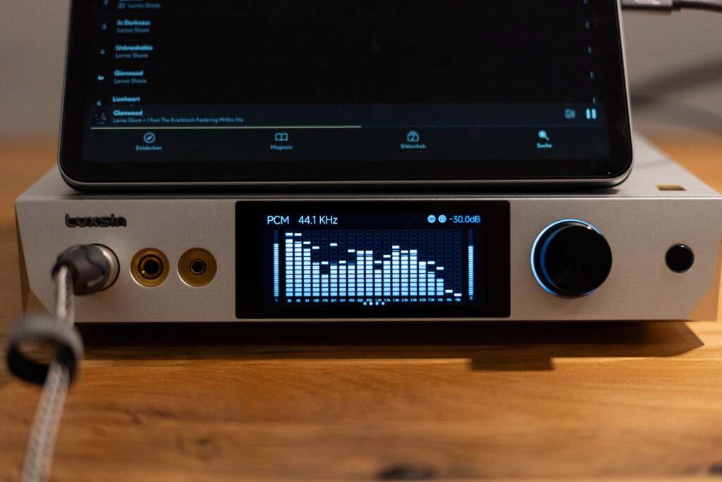 Luxsin X9 - mit Blick Frontal auf das Display mit VU-Meter und iPad mit Qobuz und spielt Glenwood von Lorna Shore
