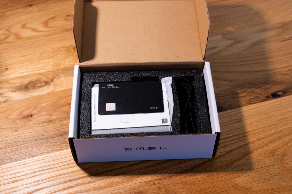 SMSL D1 - Verpackung geöffnet mit Blick auf die Garantiekarte und Kurzanleitung