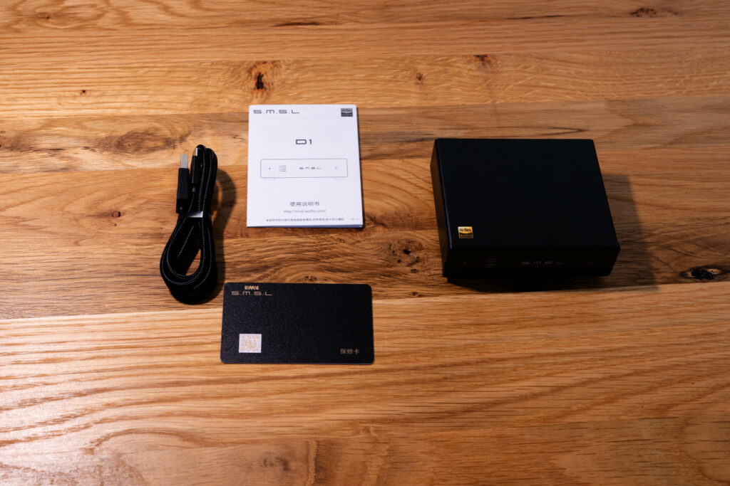 SMSL D1 - Blick auf die Garantiekarte, Kurzanleitung, USB-Kabel und das Gerät selber